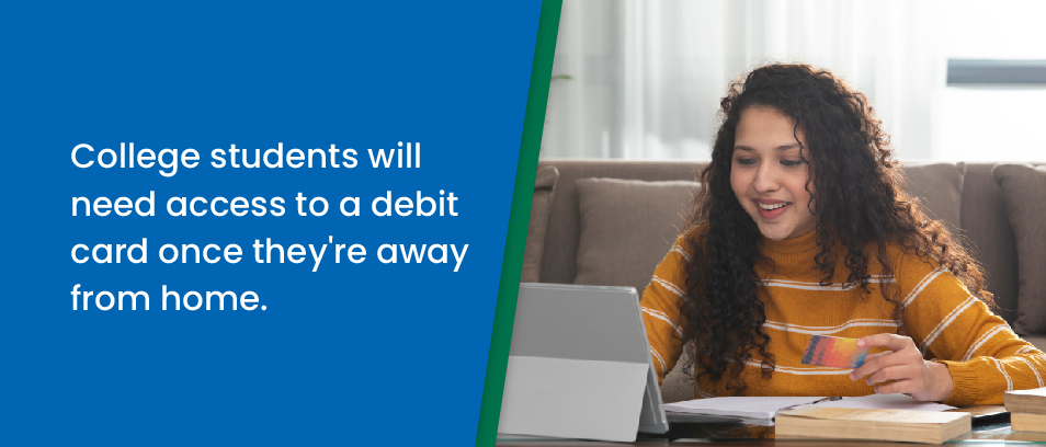 College students will need access to a debit card once they're away from home - College-aged girl looking at her laptop holding a debit card